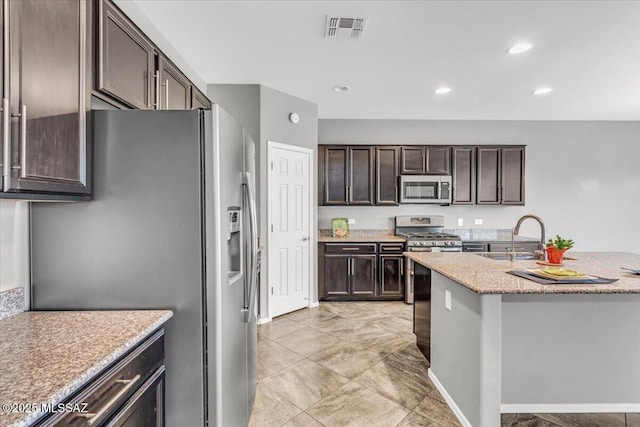3156 S Three D Ct, Tucson, AZ 85713 - kitchen featuring appliances with stainless steel finishes, a sink, dark brown cabinets, light stone countertops, and recessed lighting