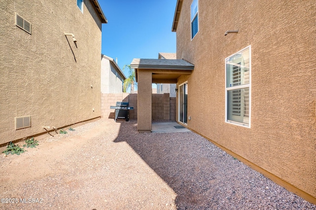 view of yard with a patio, fence, and visible vents
