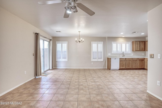 unfurnished living room with ceiling fan with notable chandelier, light tile patterned flooring, and a wealth of natural light