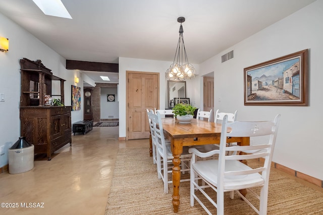 dining space with finished concrete flooring, a chandelier, baseboards, a skylight, and visible vents