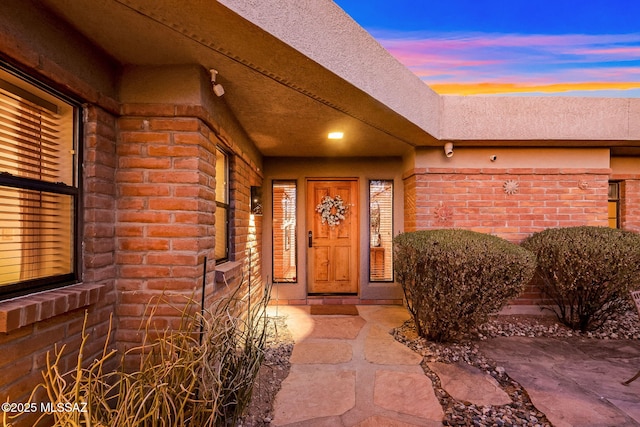 doorway to property featuring brick siding