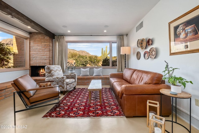living area with plenty of natural light, a brick fireplace, recessed lighting, and visible vents