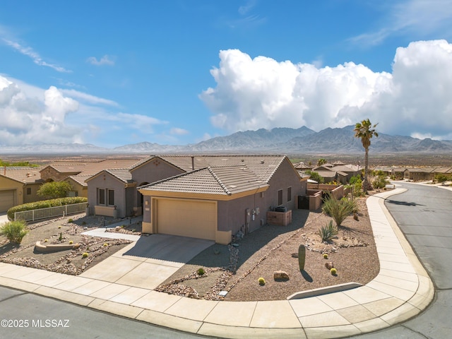 single story home featuring a garage, stucco siding, a mountain view, and driveway