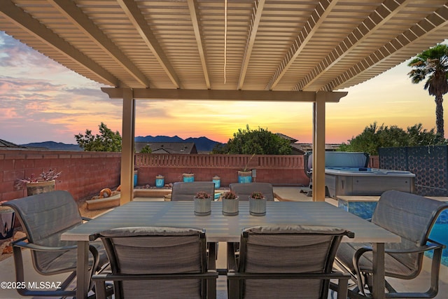 view of patio / terrace featuring outdoor dining space, a hot tub, and a fenced backyard