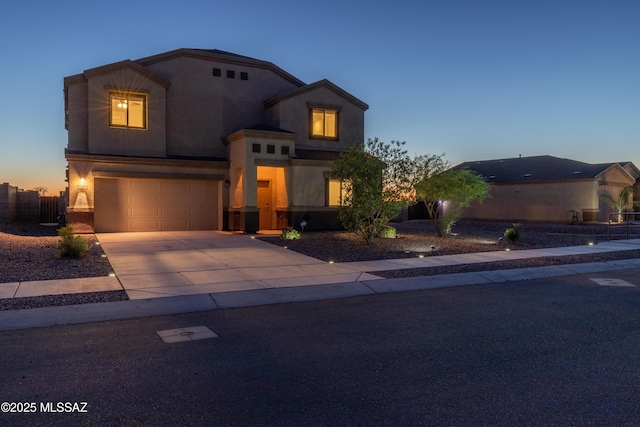 view of front facade with concrete driveway, an attached garage, and fence