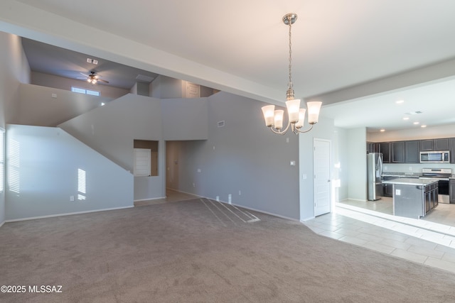 unfurnished living room featuring light carpet, baseboards, recessed lighting, ceiling fan with notable chandelier, and light tile patterned floors