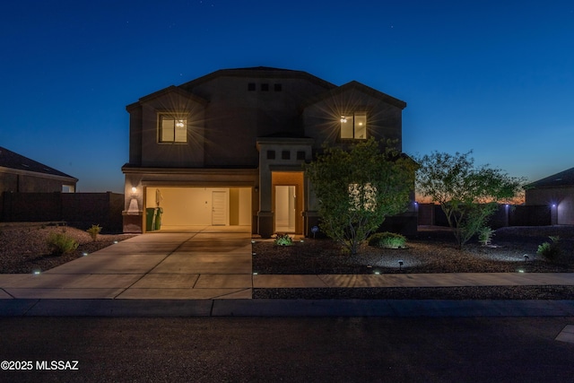 traditional home featuring a garage, fence, and concrete driveway
