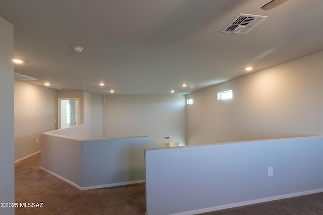 hall with an upstairs landing, carpet flooring, recessed lighting, and visible vents