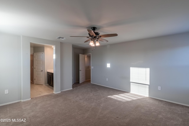 unfurnished bedroom with light colored carpet, baseboards, visible vents, and ensuite bathroom