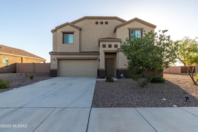 view of front of house with an attached garage, stucco siding, driveway, and fence