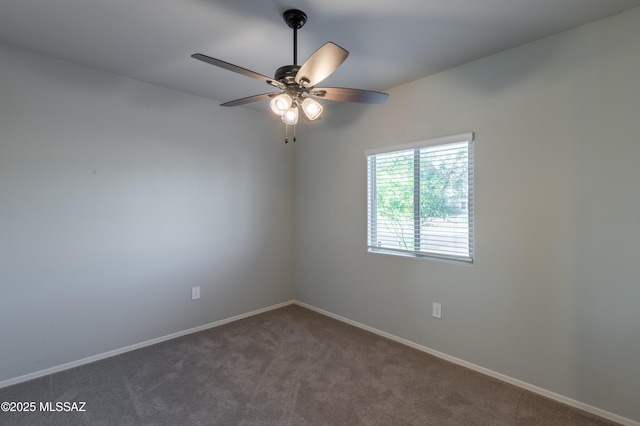 empty room with a ceiling fan, baseboards, and dark carpet