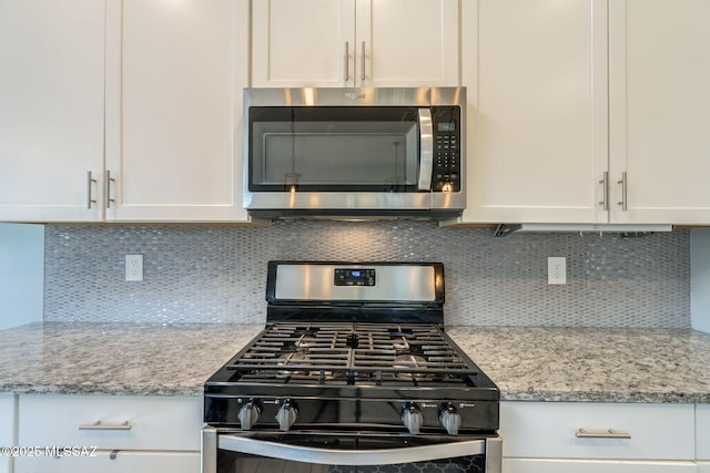 894 E Prairie Field Ln, Sahuarita, AZ 85629 - kitchen with gas range, stainless steel microwave, white cabinets, and decorative backsplash