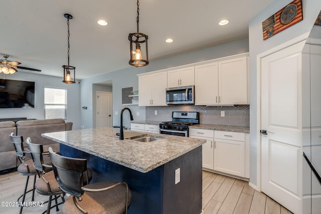 894 E Prairie Field Ln, Sahuarita, AZ 85629 - kitchen featuring appliances with stainless steel finishes, a sink, open floor plan, tasteful backsplash, and white cabinets