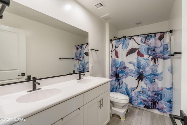 894 E Prairie Field Ln, Sahuarita, AZ 85629 - bathroom featuring toilet, double vanity, and wood finished floors