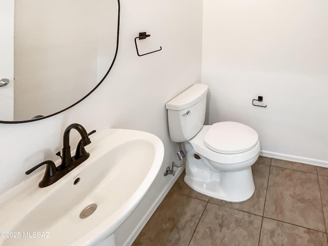 11155 E Vail Vista Ct, Tucson, AZ 85747 - half bathroom featuring toilet, baseboards, tile patterned flooring, and a sink