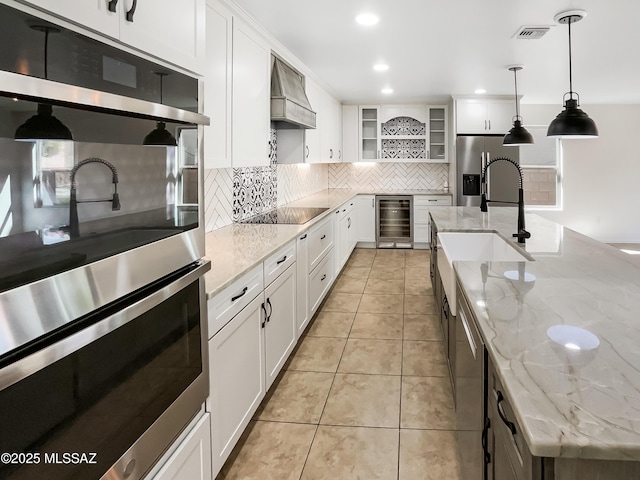 11155 E Vail Vista Ct, Tucson, AZ 85747 - kitchen with a sink, appliances with stainless steel finishes, beverage cooler, visible vents, and custom exhaust hood