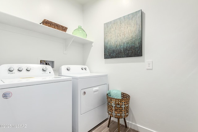 laundry area featuring washing machine and dryer, laundry area, wood finished floors, and baseboards