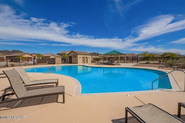community pool featuring a residential view, a patio, and fence