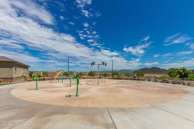 view of property's community featuring playground community and a mountain view