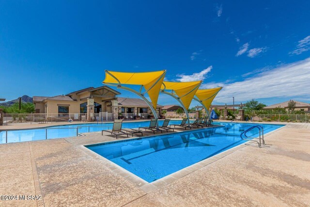 community pool with fence and a patio