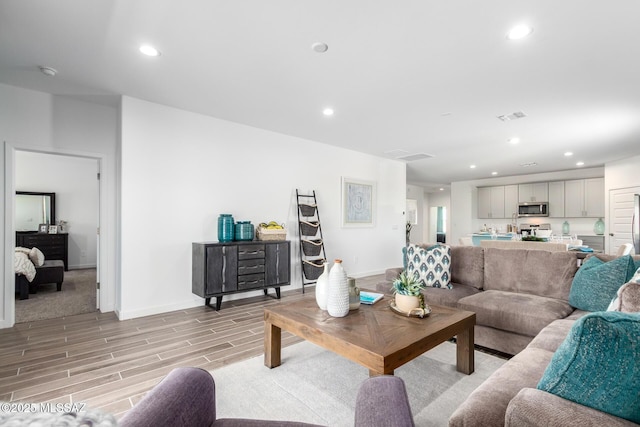 living room featuring visible vents, recessed lighting, and light wood-style floors
