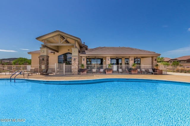 community pool featuring fence and a patio