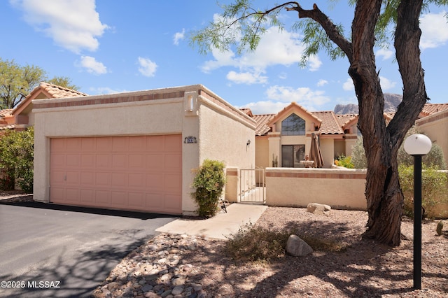 133 E Horizon Cir, Tucson, AZ 85737 - view of front of property featuring a gate, a tile roof, a fenced front yard, and stucco siding
