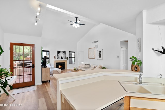 133 E Horizon Cir, Tucson, AZ 85737 - kitchen with light wood finished floors, a tile fireplace, a sink, visible vents, and open floor plan