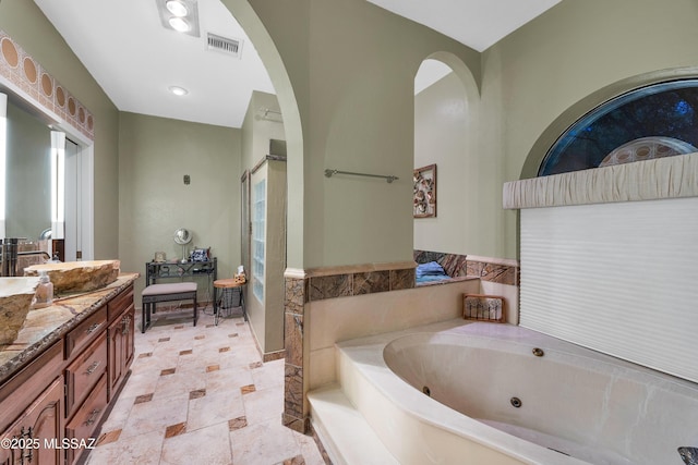full bath with visible vents, vanity, stone finish floor, a whirlpool tub, and a shower stall