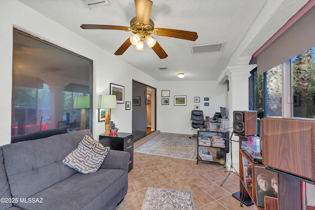 living area featuring ornate columns, ceiling fan, visible vents, and light tile patterned floors