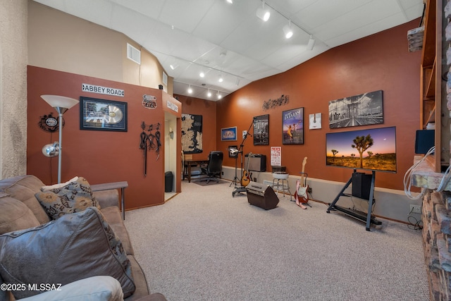 interior space with visible vents, rail lighting, lofted ceiling, and carpet flooring