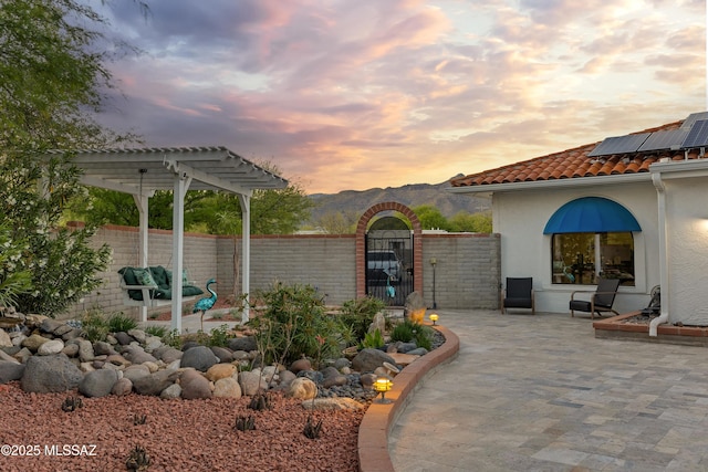 view of patio with fence, a gate, a pergola, and a mountain view