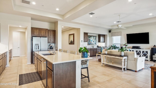 2230 E Thunder Bluff Dr, Green Valley, AZ 85614 - kitchen featuring a tray ceiling, a sink, stainless steel appliances, a kitchen bar, and ceiling fan