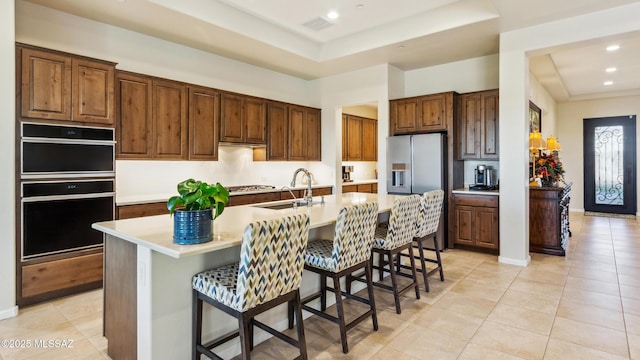 2230 E Thunder Bluff Dr, Green Valley, AZ 85614 - kitchen featuring a raised ceiling, a sink, a kitchen island with sink, light countertops, and light tile patterned floors