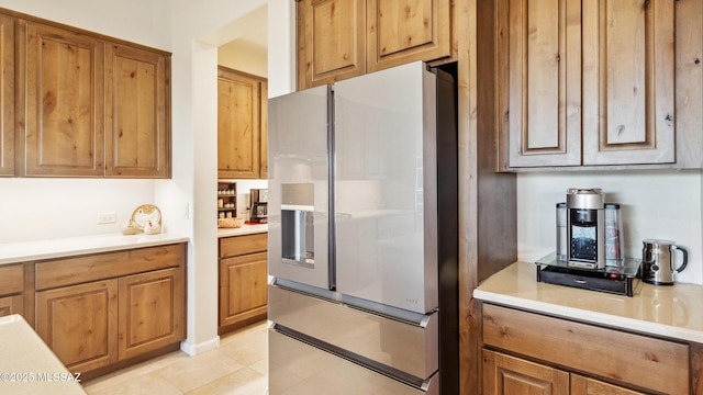 2230 E Thunder Bluff Dr, Green Valley, AZ 85614 - kitchen with stainless steel fridge, light countertops, brown cabinetry, and light tile patterned flooring