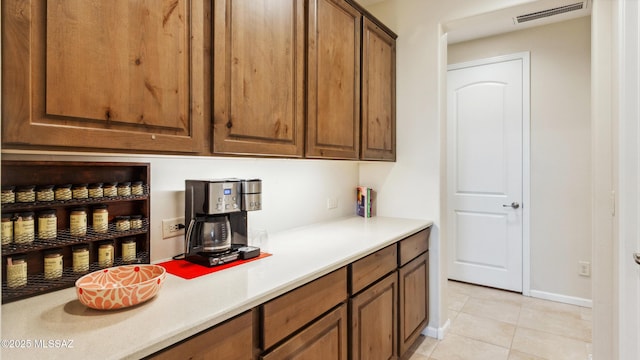 2230 E Thunder Bluff Dr, Green Valley, AZ 85614 - kitchen featuring light countertops, light tile patterned flooring, and brown cabinets