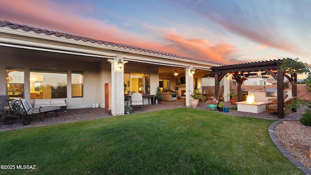 2230 E Thunder Bluff Dr, Green Valley, AZ 85614 - back of house at dusk featuring an outdoor living space with a fire pit, a patio area, a yard, a pergola, and stucco siding