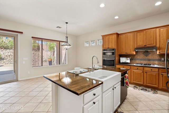 4706 W Cholla Bluff Dr, Marana, AZ 85658 - kitchen featuring dark countertops, under cabinet range hood, multiple ovens, stainless steel gas stovetop, and recessed lighting