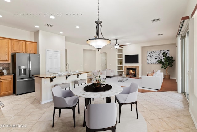 4706 W Cholla Bluff Dr, Marana, AZ 85658 - dining room featuring light tile patterned floors, ceiling fan, recessed lighting, built in shelves, and arched walkways