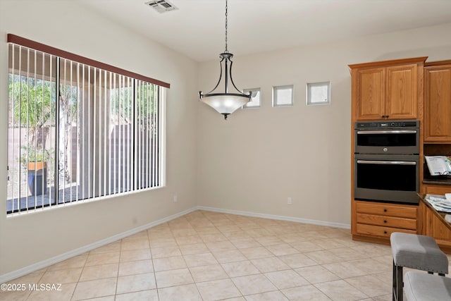 4706 W Cholla Bluff Dr, Marana, AZ 85658 - kitchen with double oven, hanging light fixtures, baseboards, dark countertops, and brown cabinets