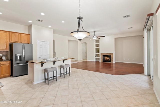 4706 W Cholla Bluff Dr, Marana, AZ 85658 - kitchen featuring stainless steel fridge, arched walkways, recessed lighting, ceiling fan, and a kitchen breakfast bar