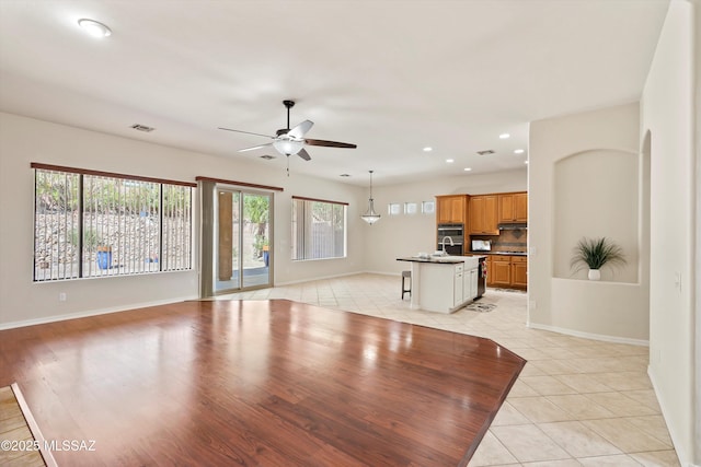 4706 W Cholla Bluff Dr, Marana, AZ 85658 - unfurnished living room featuring a ceiling fan, light tile patterned floors, baseboards, recessed lighting, and a sink