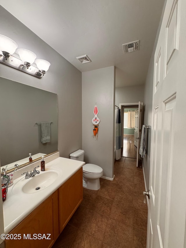 bathroom featuring tile patterned floors, toilet, visible vents, and vanity