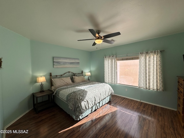 bedroom featuring a ceiling fan, visible vents, wood finished floors, and baseboards