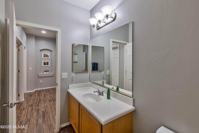 14472 S Camino Tierra Monte, Sahuarita, AZ 85629 - half bath featuring wood finished floors, vanity, toilet, a chandelier, and baseboards