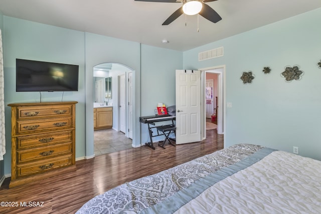 14472 S Camino Tierra Monte, Sahuarita, AZ 85629 - bedroom with arched walkways, wood finished floors, a ceiling fan, ensuite bathroom, and baseboards