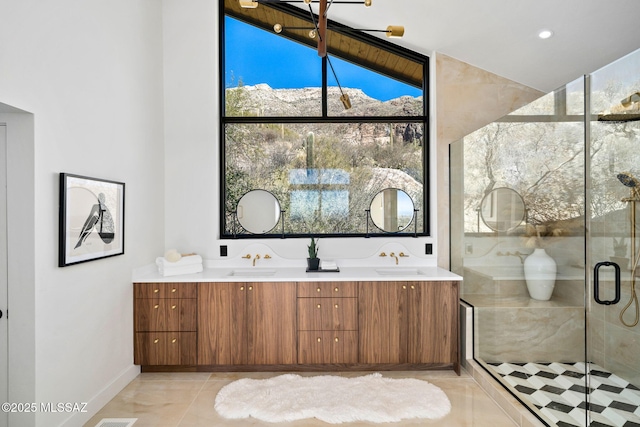 bathroom with a stall shower, tile patterned flooring, a sink, and double vanity