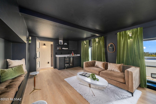 living area featuring light wood-style flooring and a bar