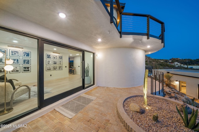 property entrance featuring stucco siding and a balcony