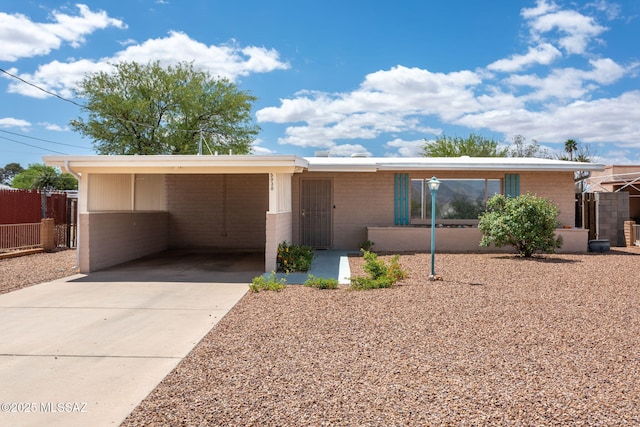 5930 E 32nd St, Tucson, AZ 85711 - single story home featuring concrete driveway, fence, an attached carport, and brick siding
